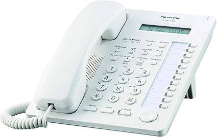 White Panasonic KX-T7730 telephone with keypad and display screen, showing a classic office phone design.