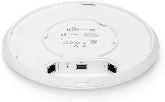 Ubiquiti UAP-AC-PRO Unifi AP AC Pro wireless access point mounted on a wall, showing its sleek design and LED indicator lights.